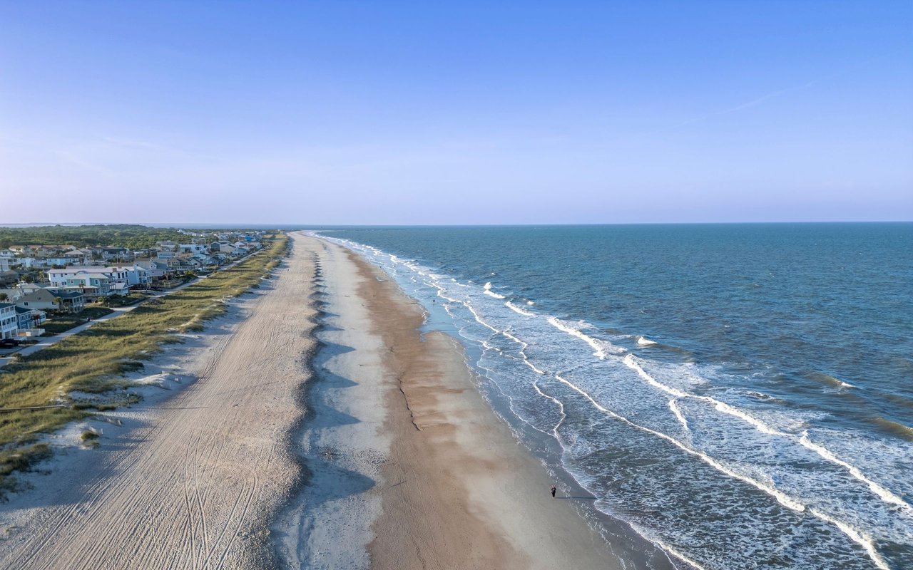Aerial view of Amelia Island beach, with ocean waves and homes along the dunes.