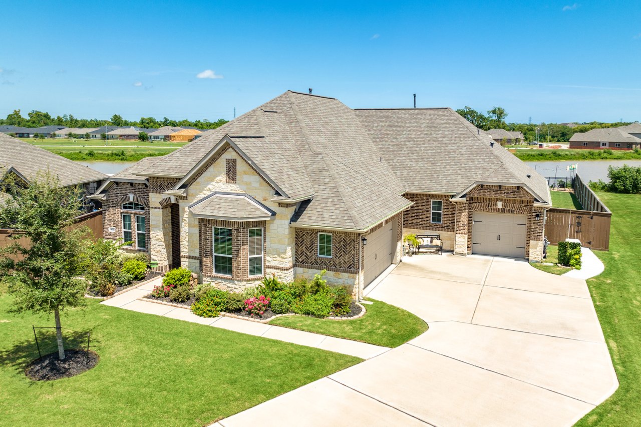 Brown and Red Brick with White Stone 3 car garage home, with the lake as backyard in Clute - Lake Jackson Texas