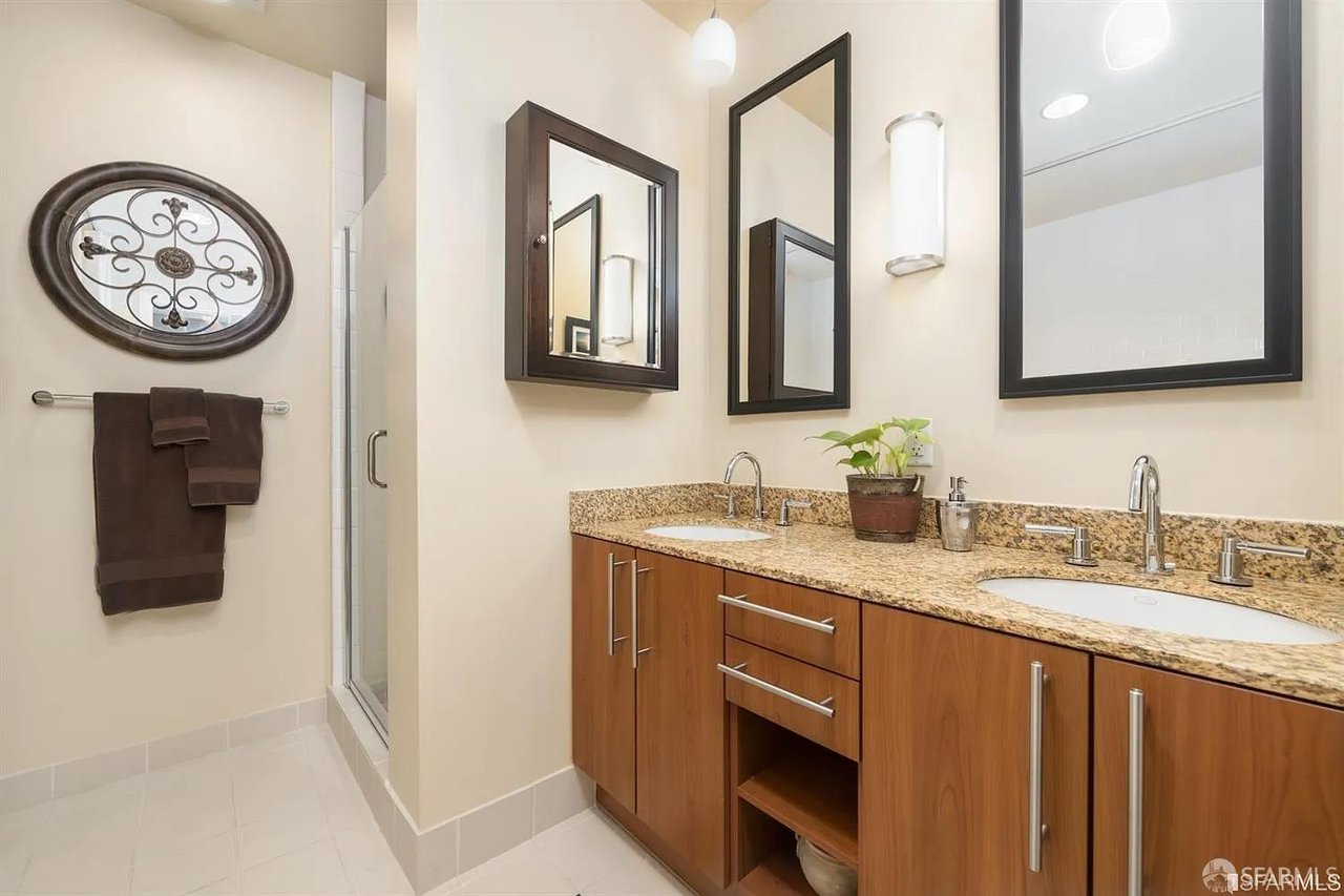 Bathroom vanity with wood cabinets and framed mirrors
