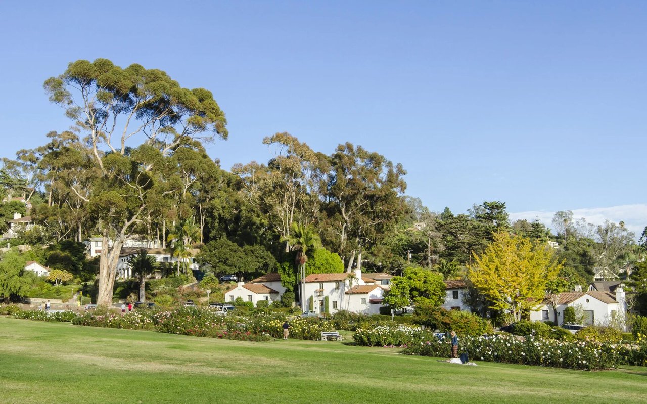 Elysian Park lawn and rose garden with hillside homes and mature trees.