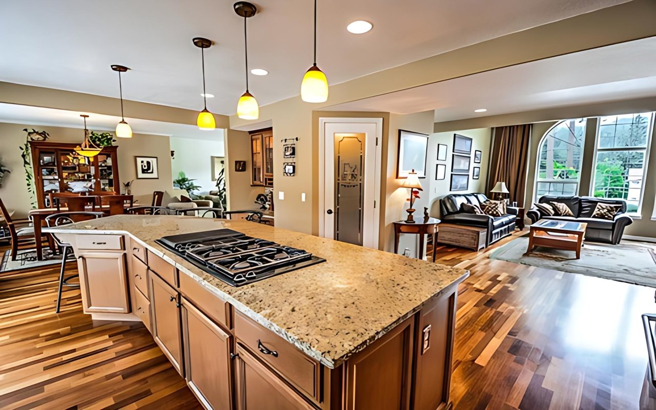 Open-plan kitchen with a large granite island and gas cooktop adjoining a bright living room.