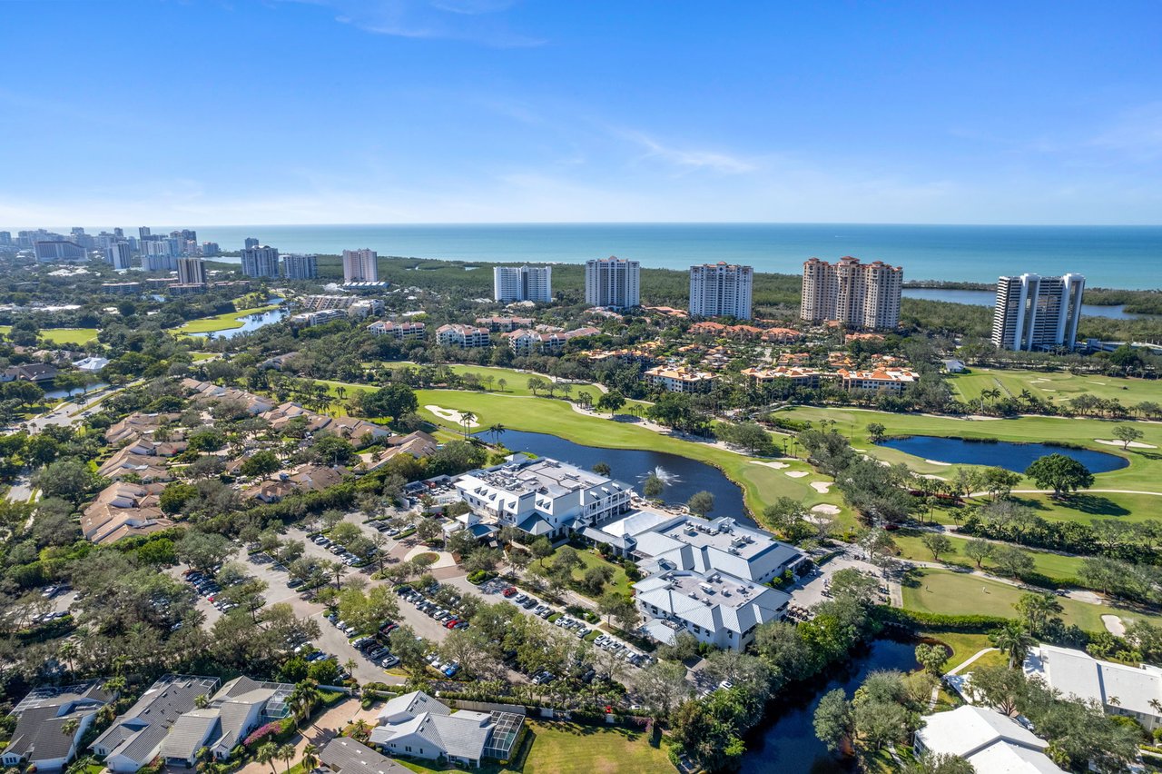 Aerial view of Pelican Bay, with the Gulf, golf course, and coastal high-rises.