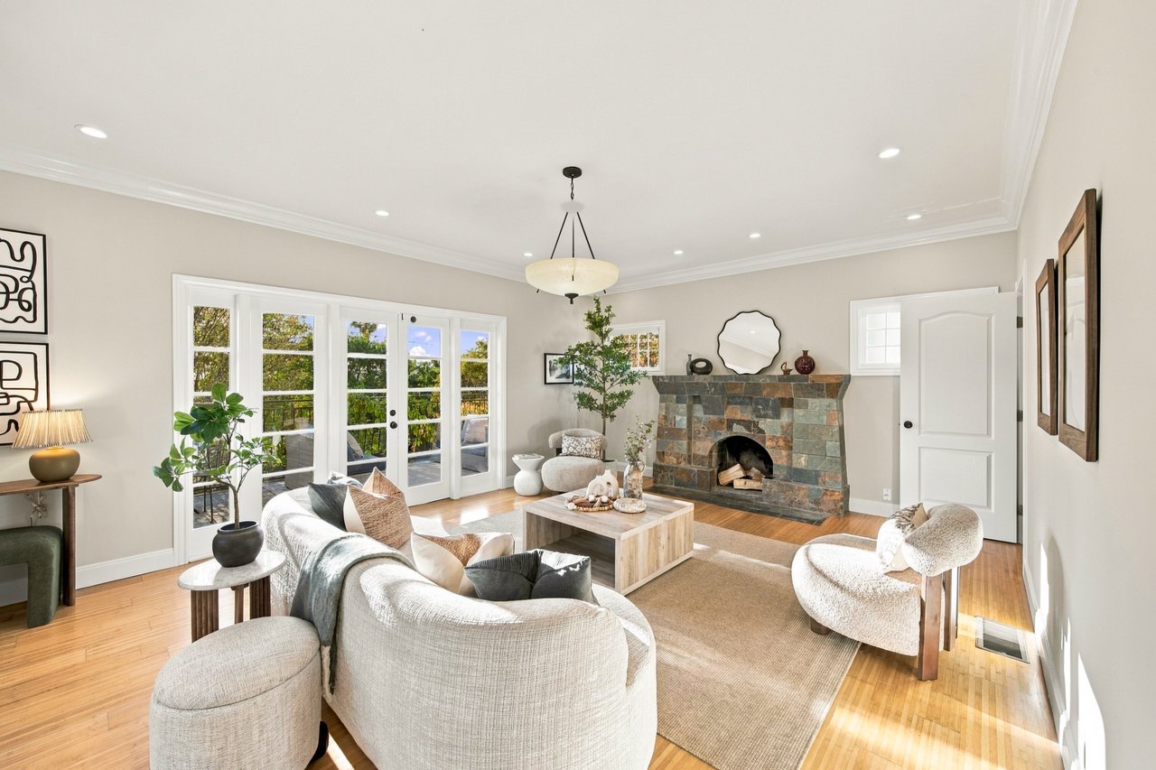 Furnished living room with a slate fireplace, French doors, and hardwood floors.
