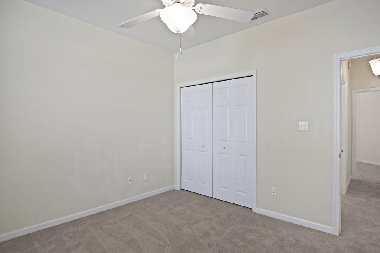 Bedroom at 5441 Hampton Hill Circle, Tallahassee, Florida 32311 featuring ceiling fan, double closet doors, and neutral carpet flooring.