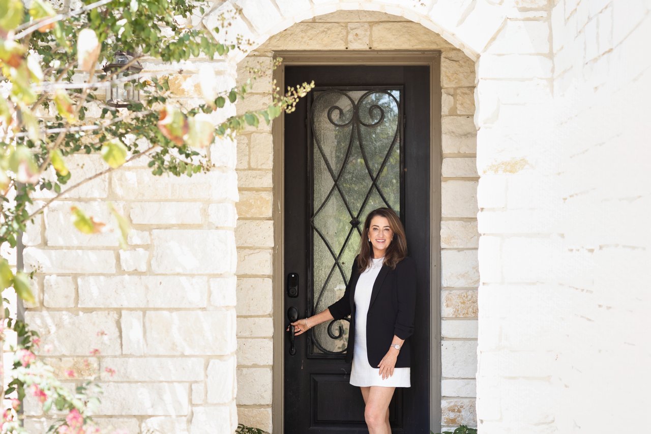 Jeannie Garr Roddy standing at a stone home's ornate front door.