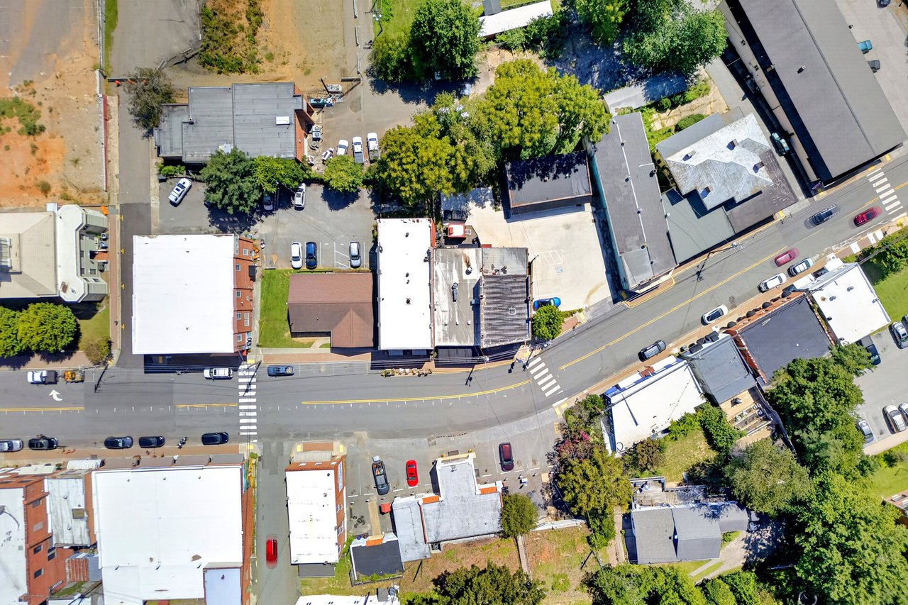 Aerial view of a downtown commercial block with a street intersection and surrounding buildings.