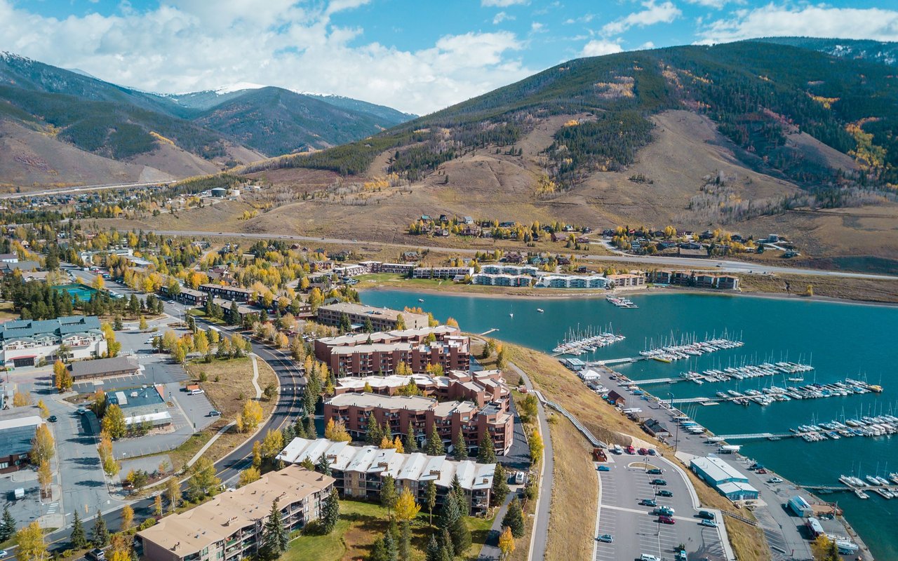 Aerial view of Dillon and Lake Dillon marina, with autumn foliage and mountain slopes.