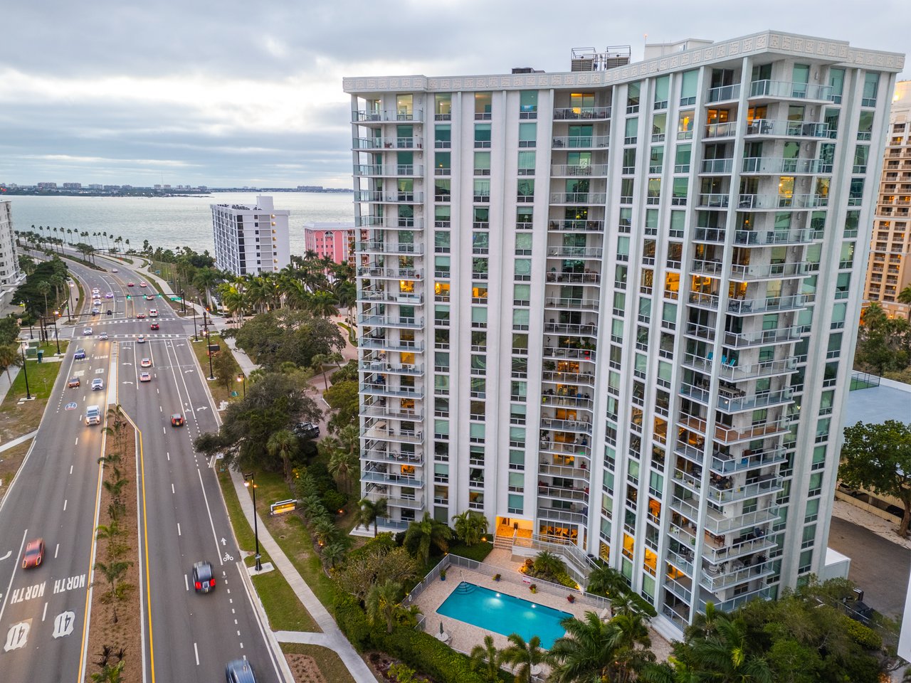 One Watergate condominium tower beside Sarasota Bay, with balconies and a swimming pool.
