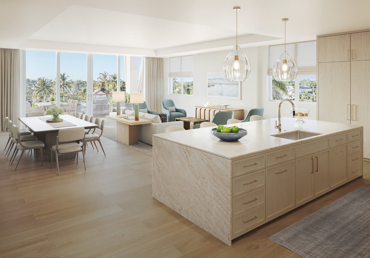 Open-plan kitchen with a marble island overlooking the dining and living areas and a palm-lined terrace.