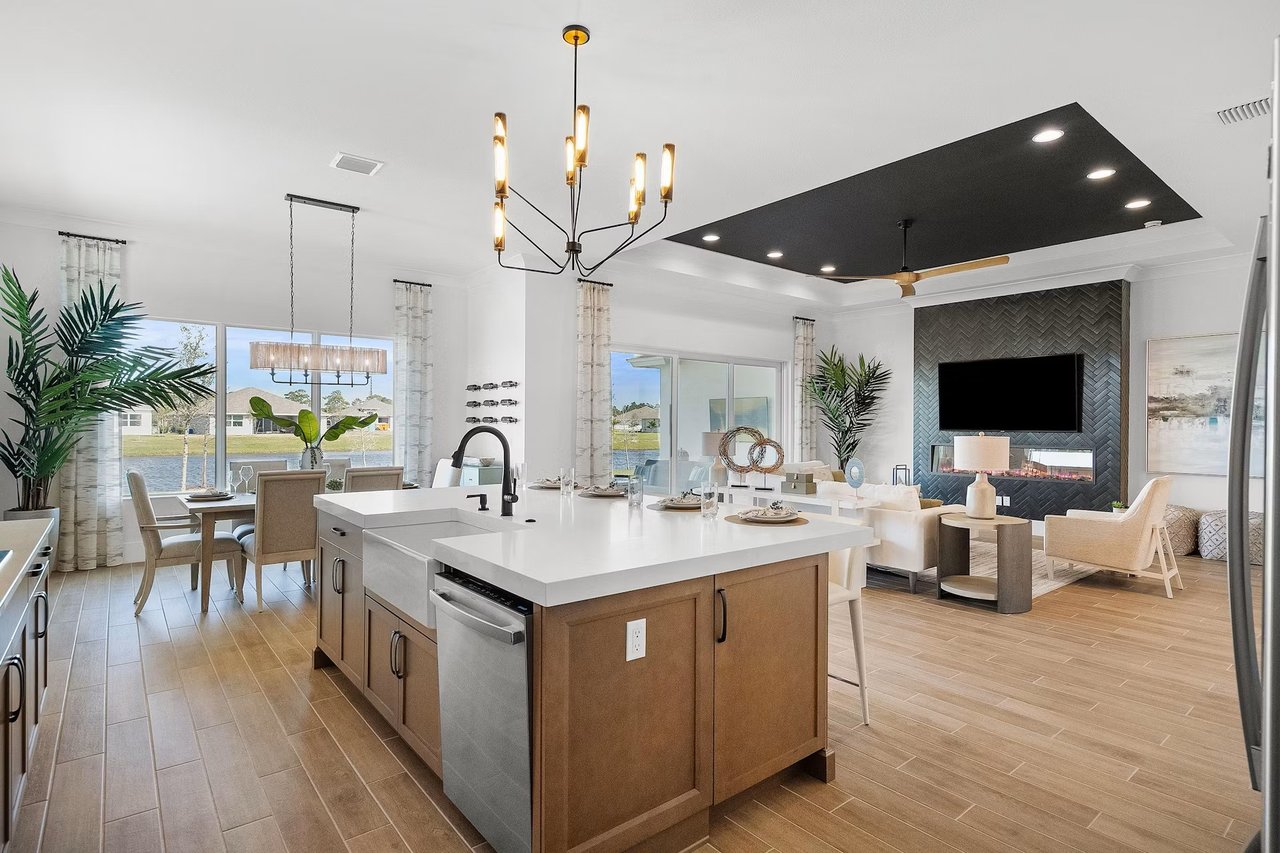 Open-plan kitchen with a large wood-paneled island and waterfront views through the windows.