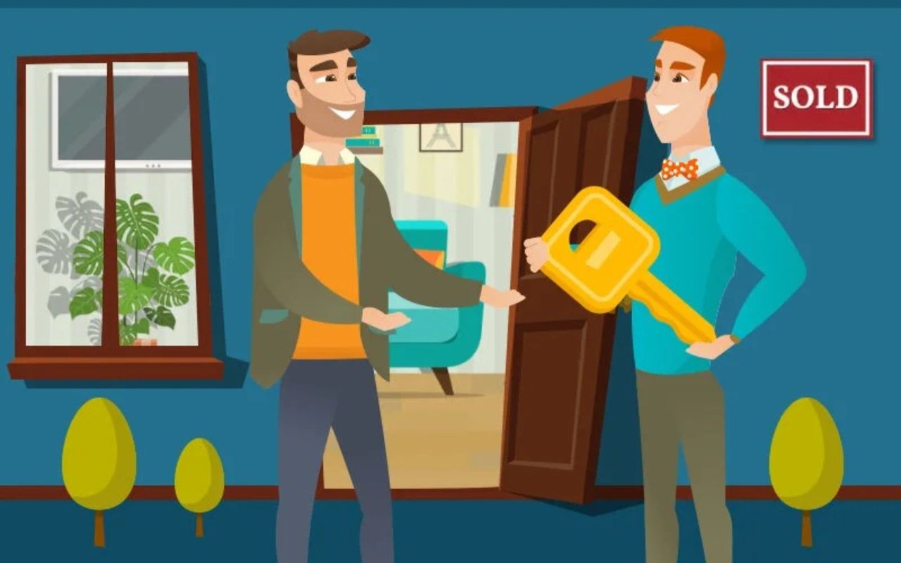Real estate agent hands a buyer a large yellow key beside a SOLD sign.