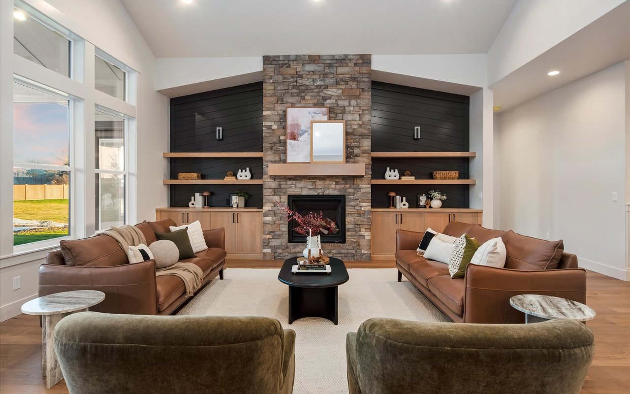 Great room with stone fireplace, oak wood built-ins and black shiplap walls
