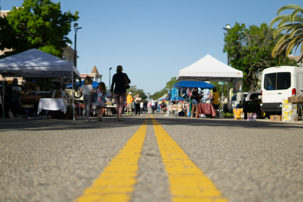 People shopping at a Sonoma County farmers market with fresh produce and local goods
