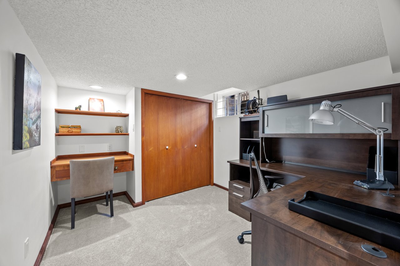 Home office with a dark built-in desk and a smaller wall-mounted writing desk.