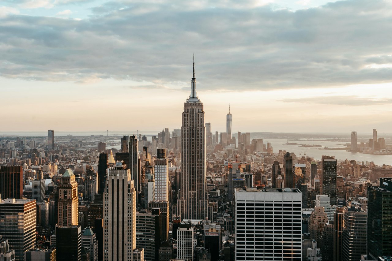 Midtown Manhattan skyline with Empire State Building and high-rise condos at sunset.