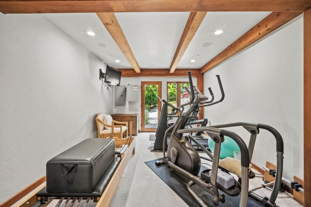 Home gym with equipment and patio access in $5.5M Carmel Highlands timber home