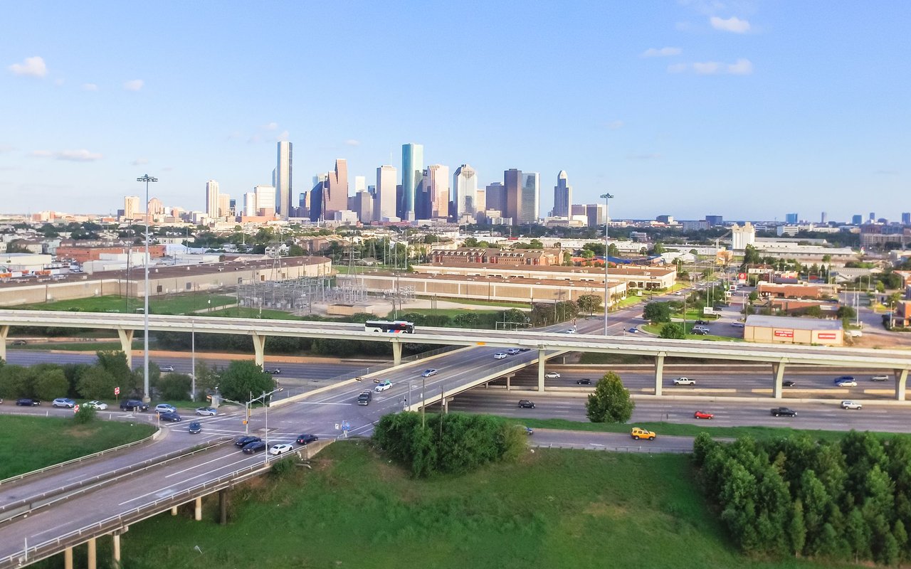 Houston skyline beyond elevated highway interchanges.