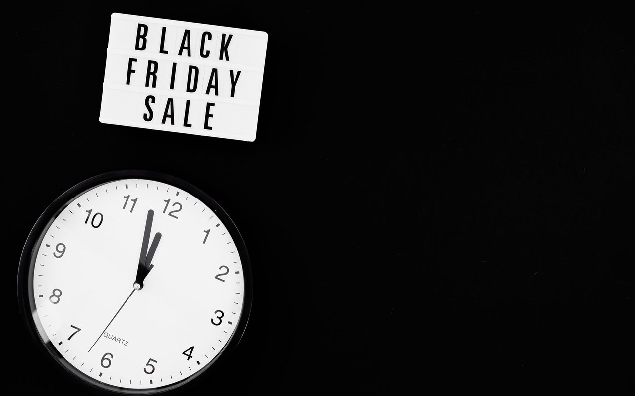 Black Friday Sale sign above a large analog clock against a black background.
