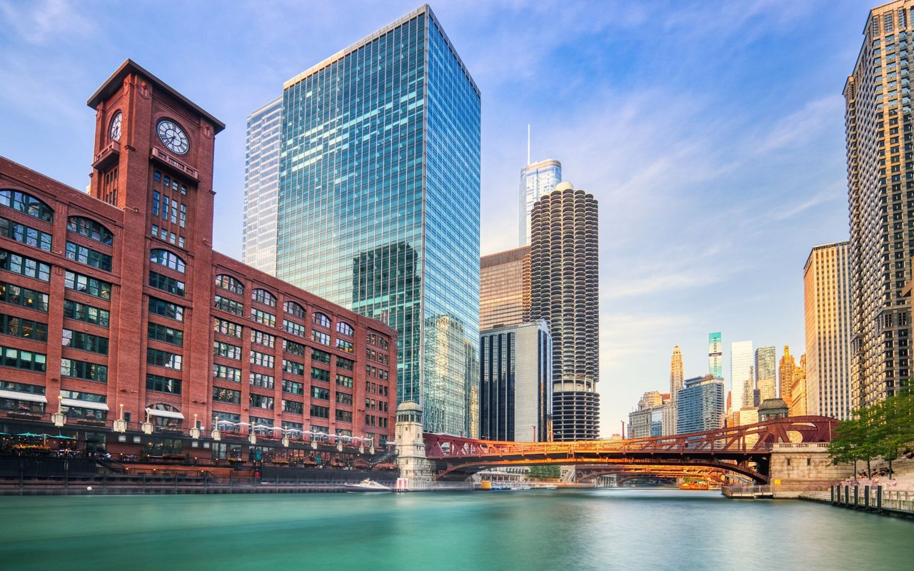Downtown Chicago skyline along the river, with Marina City towers and a red bridge.