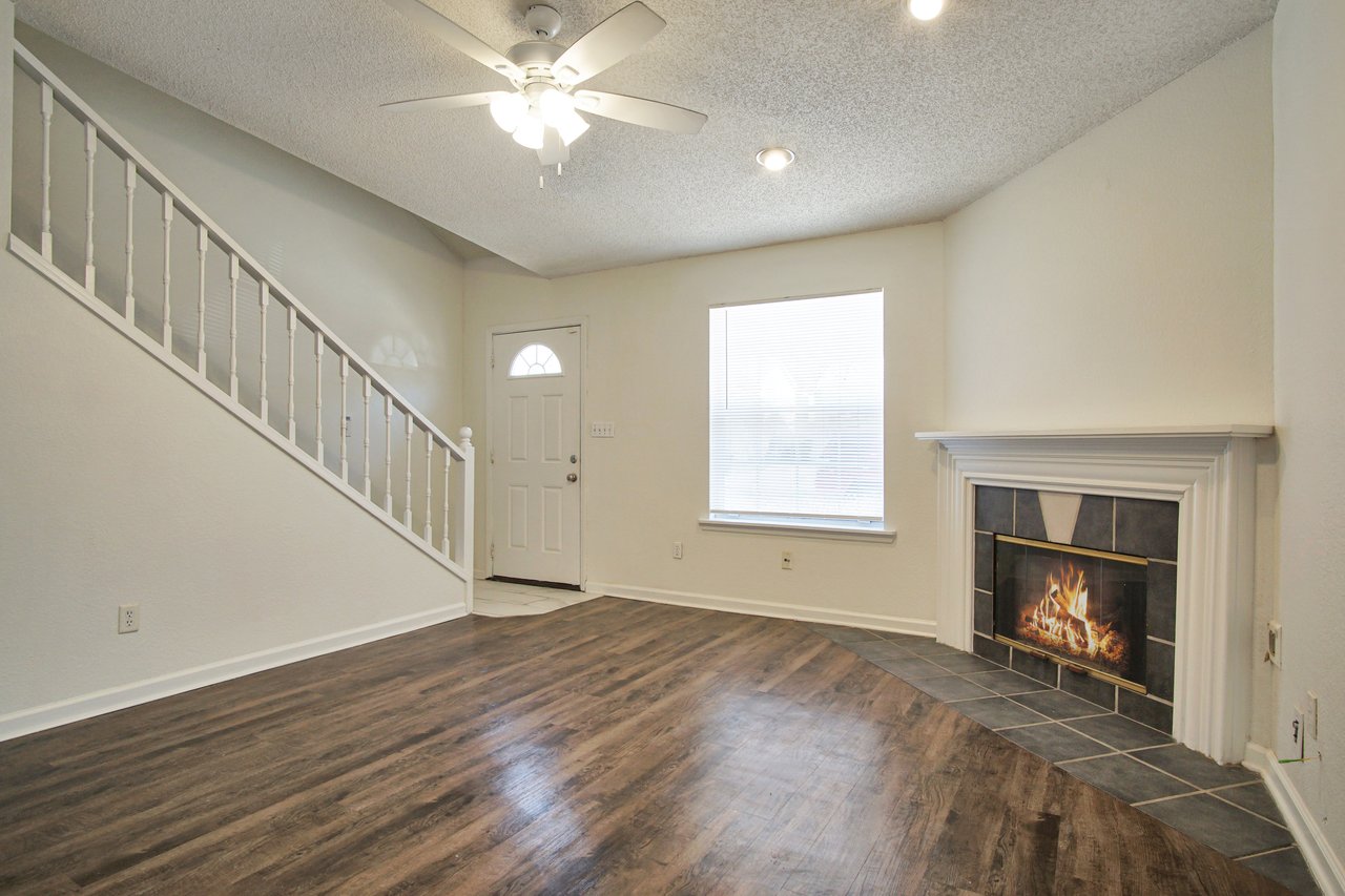 A cozy room featuring a fireplace and elegant hardwood floors, creating a warm and inviting atmosphere.