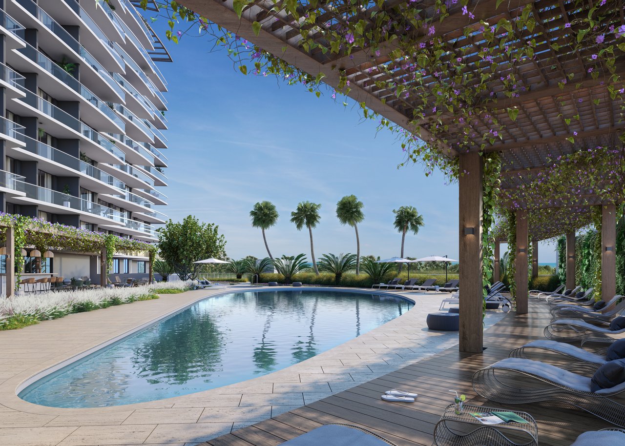 Residential pool beside a modern high-rise, with palm trees and a flower-covered pergola.