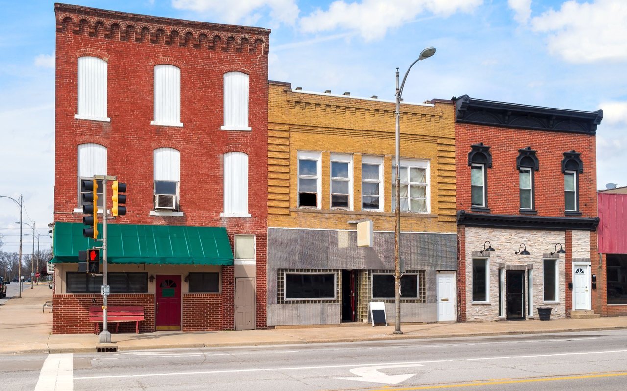 Historic downtown storefronts with red and yellow brick façades and a green awning.