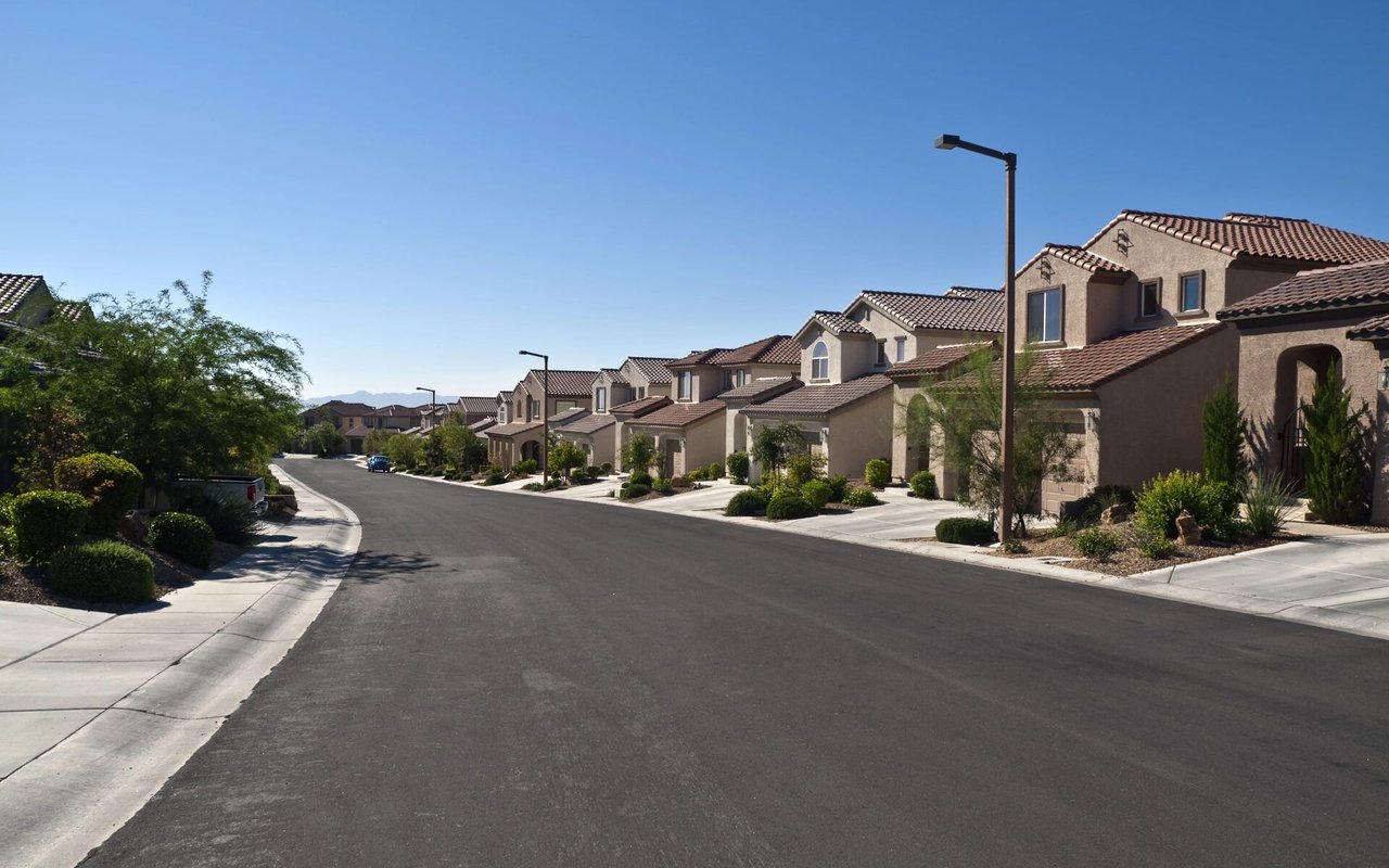 Residential street in Montreux lined with stucco homes, tile roofs, and landscaped front yards.