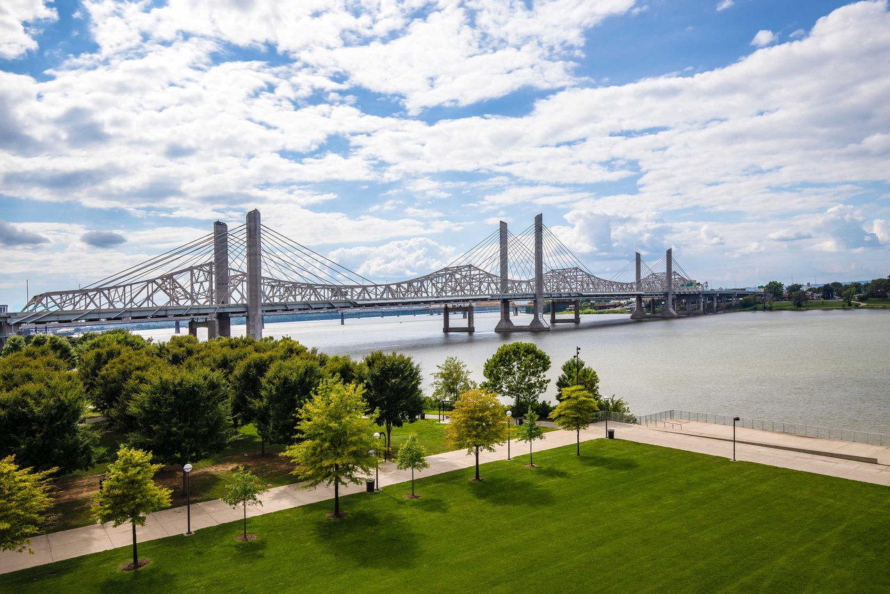 view of green space and bridge spanning the Ohio River