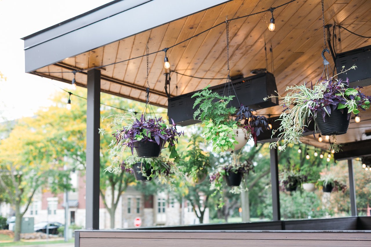 A modern outdoor patio in a Madison, Wisconsin neighborhood featuring hanging plants and string lights, illustrating how Tax Increment Financing (TIF) districts fund local infrastructure and enhance property values.