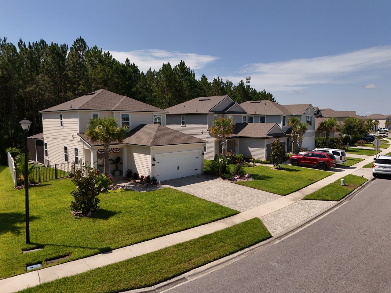 Attached two-story homes with garages and palm trees along a landscaped suburban street.