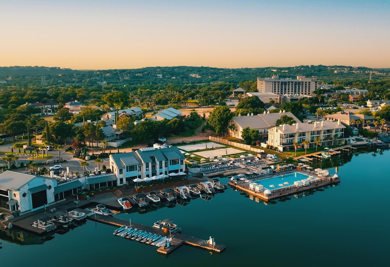 Horseshoe Bay waterfront homes and marina beside a pool and wooded hills.