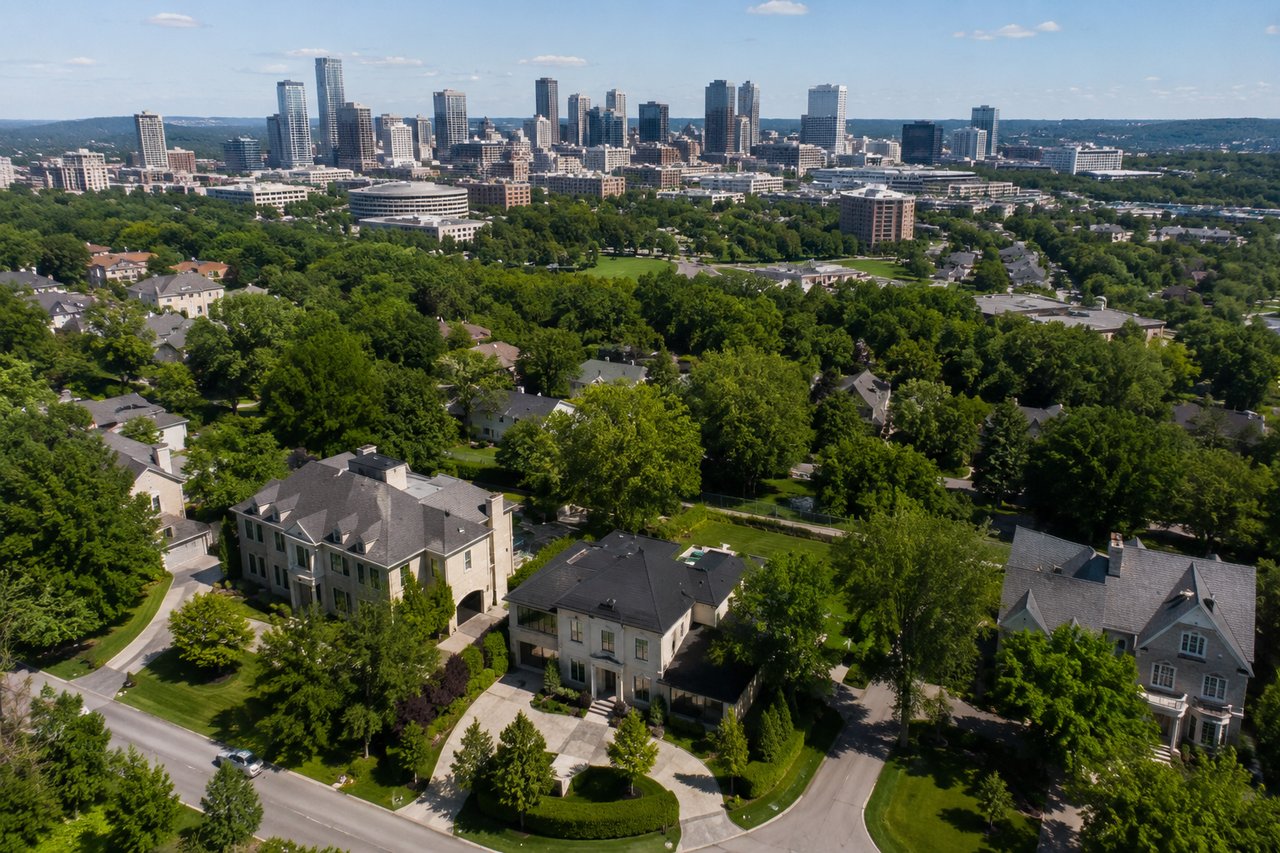 Aerial view of luxury homes surrounded by mature trees with the Nashville skyline in the background, illustrating changing luxury home inventory, new construction, and evolving market trends in Nashville, Tennessee during 2026.