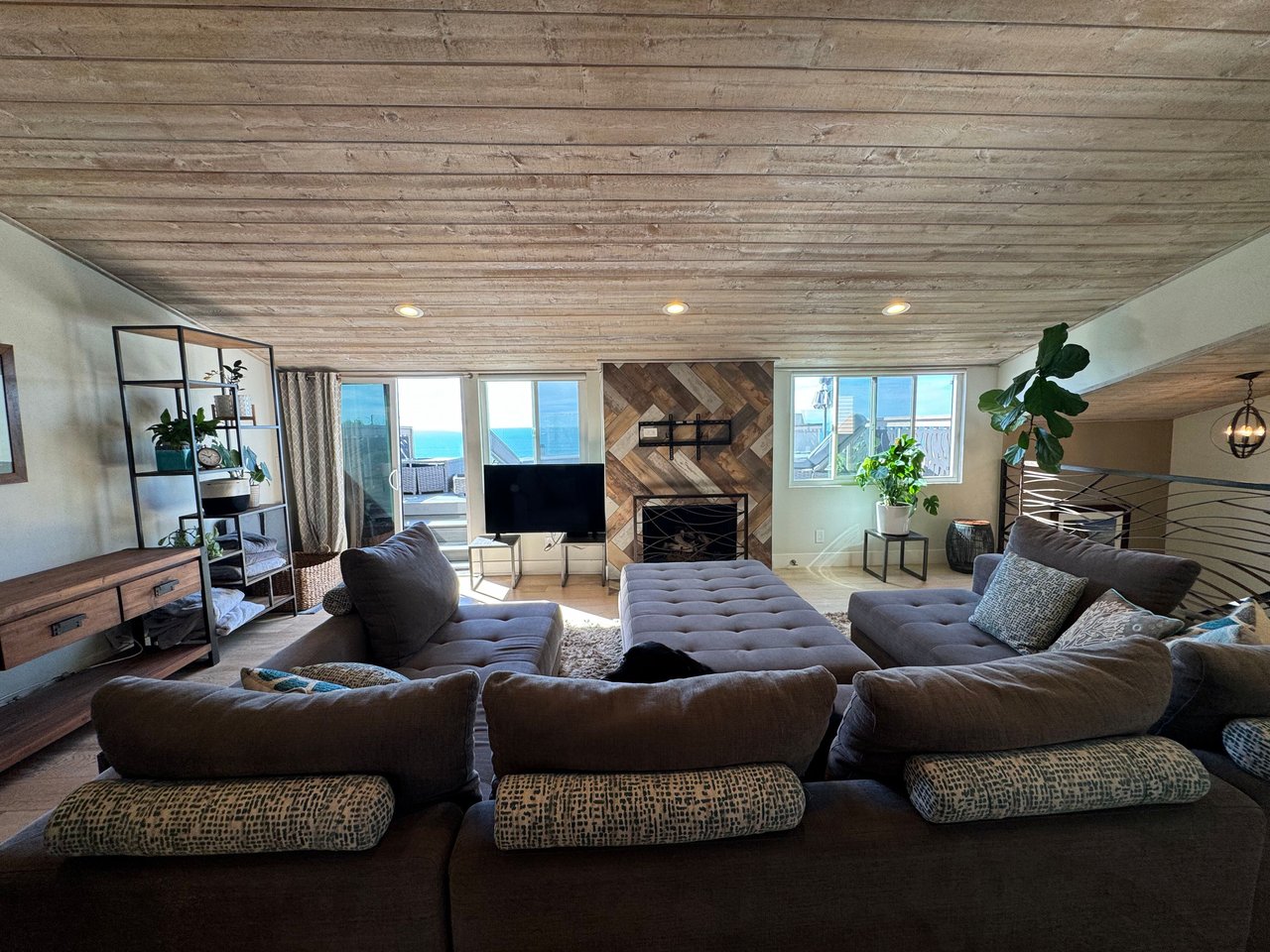 Spacious living room with modern decor, large sectional sofa, fireplace, and ocean view balcony at 533 S Sierra Ave, Solana Beach, CA 92075.