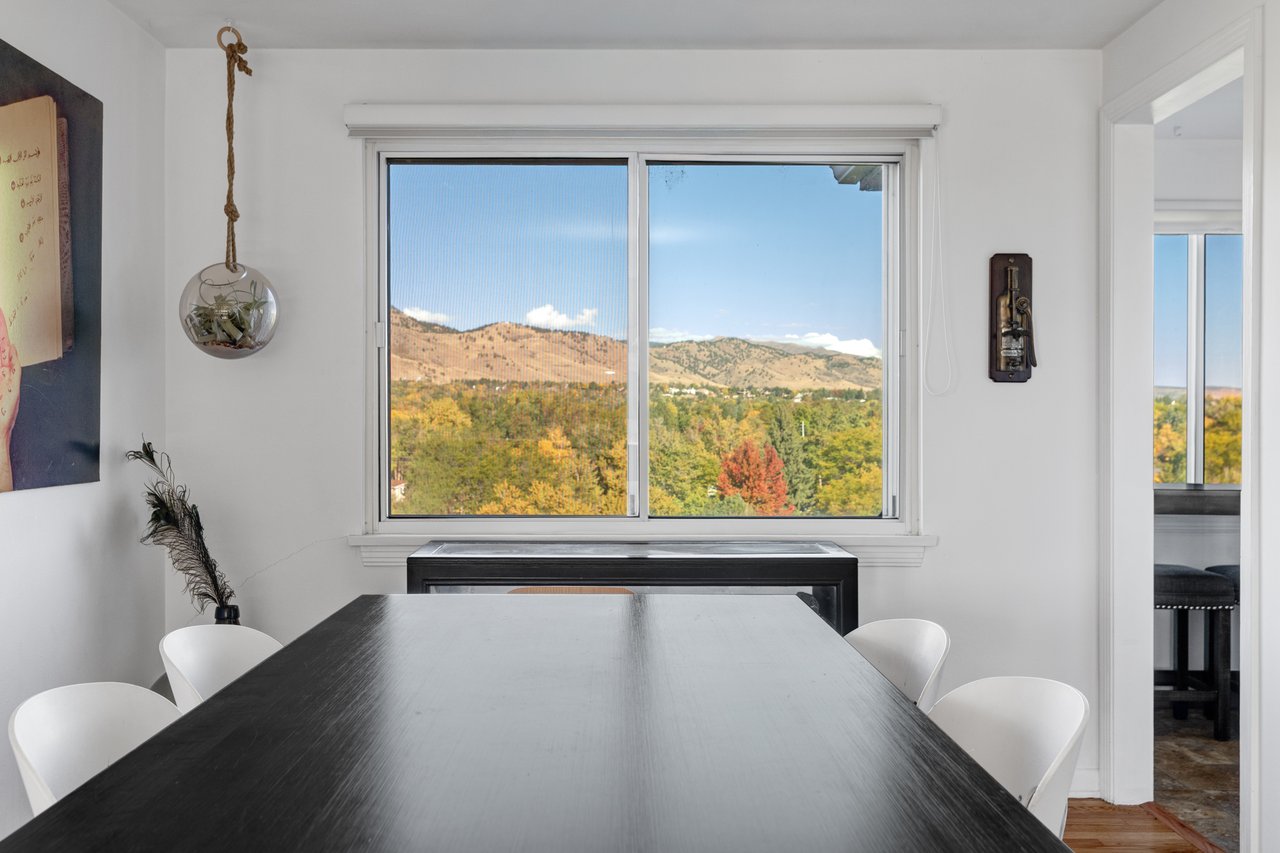 Dining room at 2003 Balsam Drive with a dark wood table and a window framing foothill views