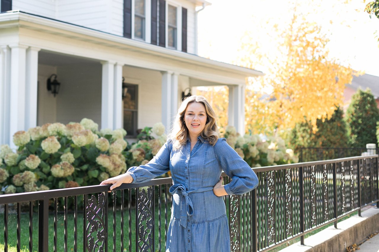 Cait Berry, local real estate advisor with Insiders Realty, standing outside a classic white single-family home in Middleton, WI. Partnering with a local expert is the key to properly pricing and preparing your home to sell in days, not months.