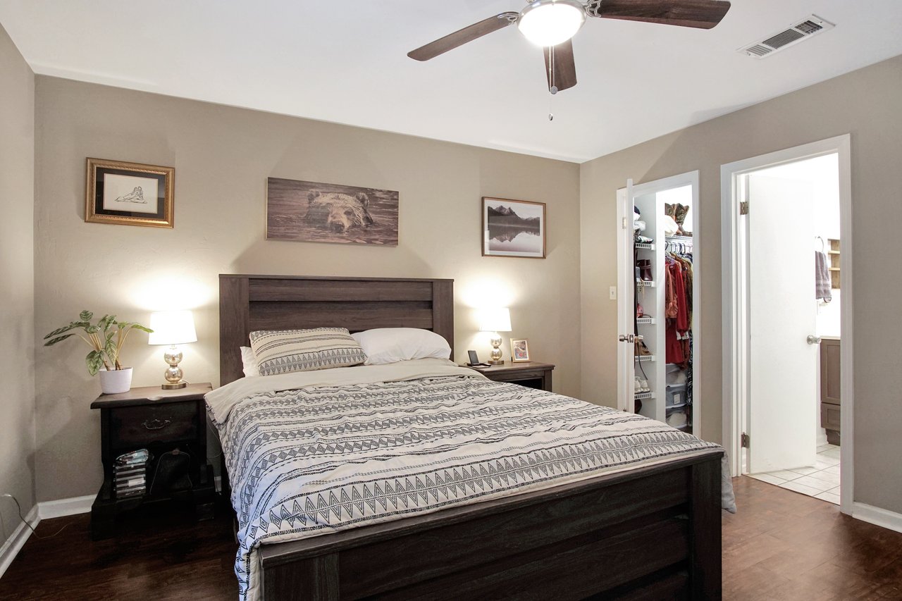 A cozy bedroom featuring a bed, a dresser, and a ceiling fan for a comfortable atmosphere.