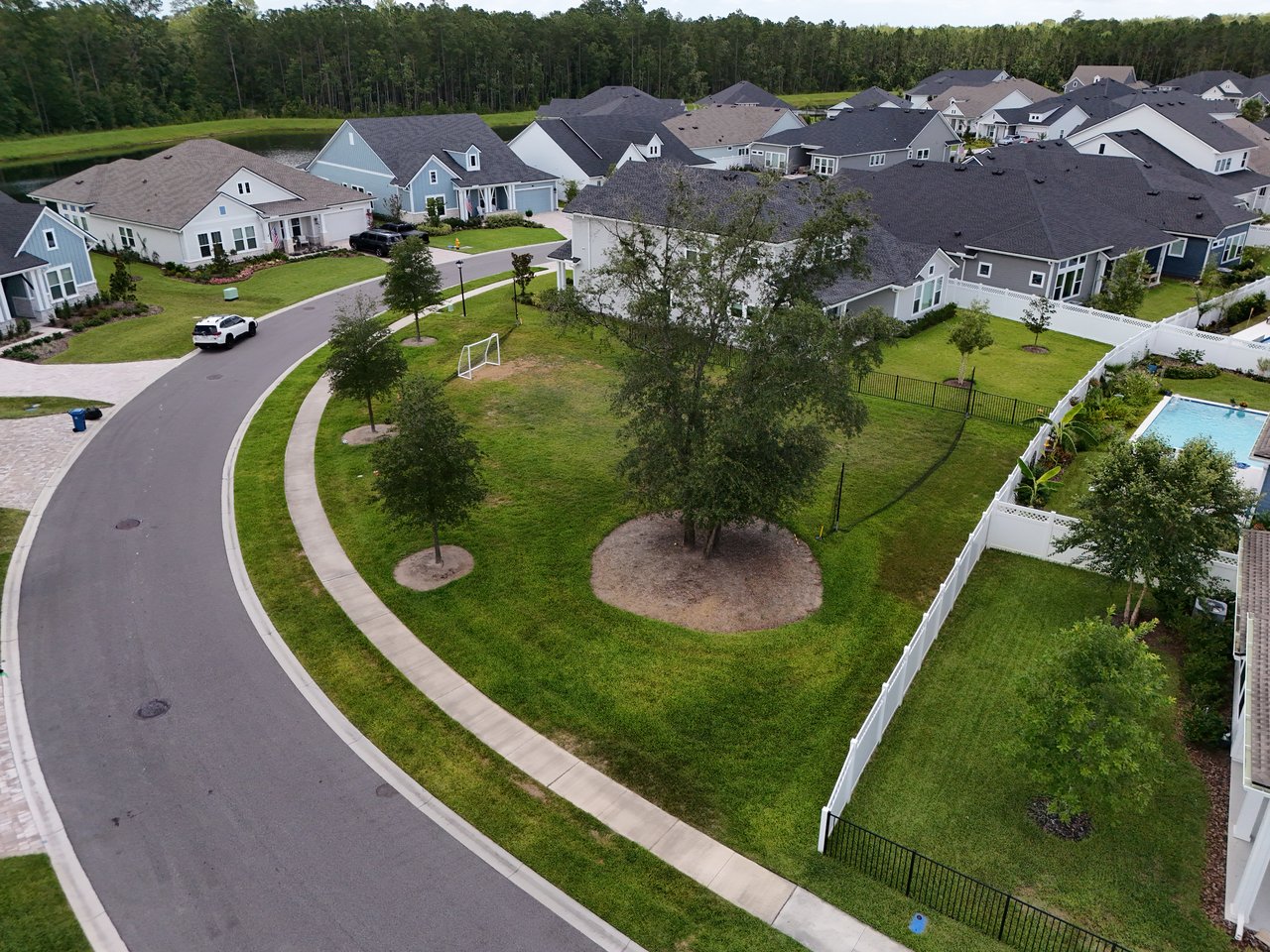 Aerial view of Oak Grove homes around a grassy common area with trees and a soccer goal.