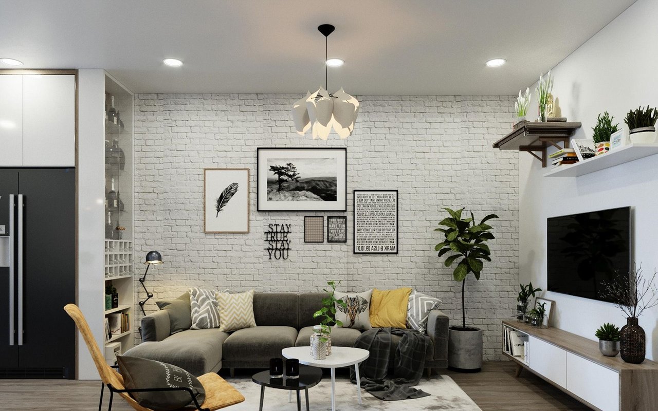 Modern living room with gray sectional, white brick accent wall, and yellow accent chair.