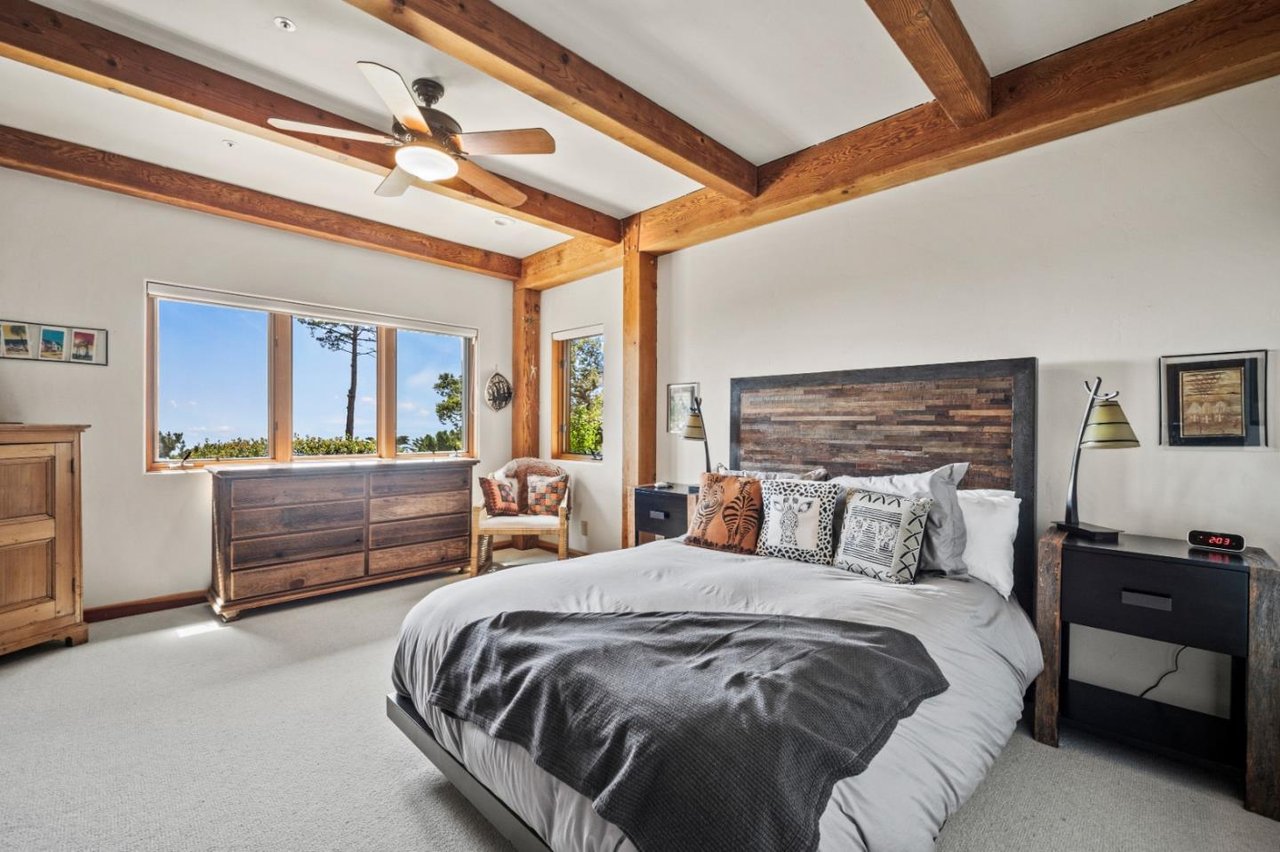 Secondary bedroom with large windows and ocean views in Carmel Highlands timber home