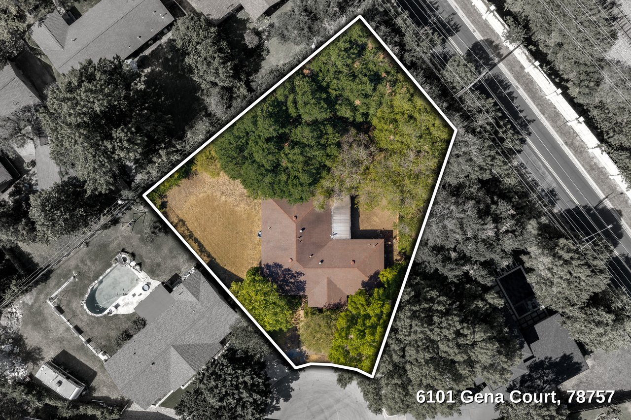 Aerial view of a house and wooded lot outlined in white at 6101 Gena Court.