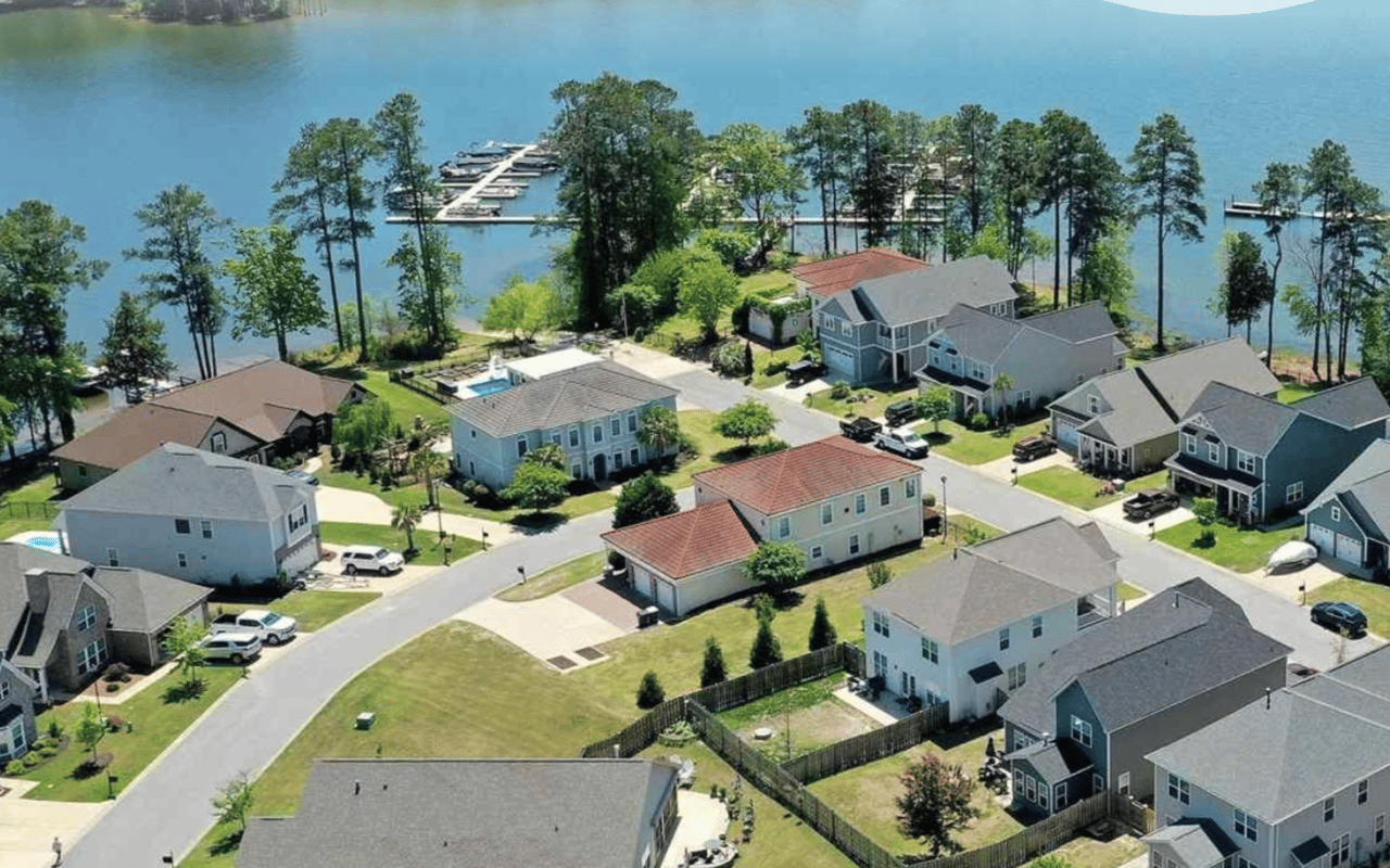 Aerial view of lakeside homes and docks along a blue lake.