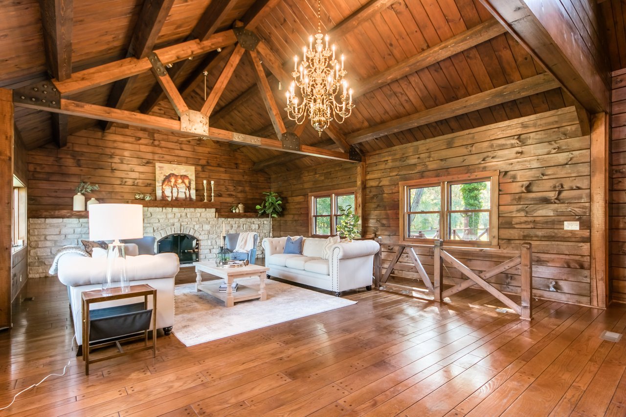 Timber home interior with vaulted wood ceiling, stone fireplace, and architectural details requiring thoughtful real estate positioning