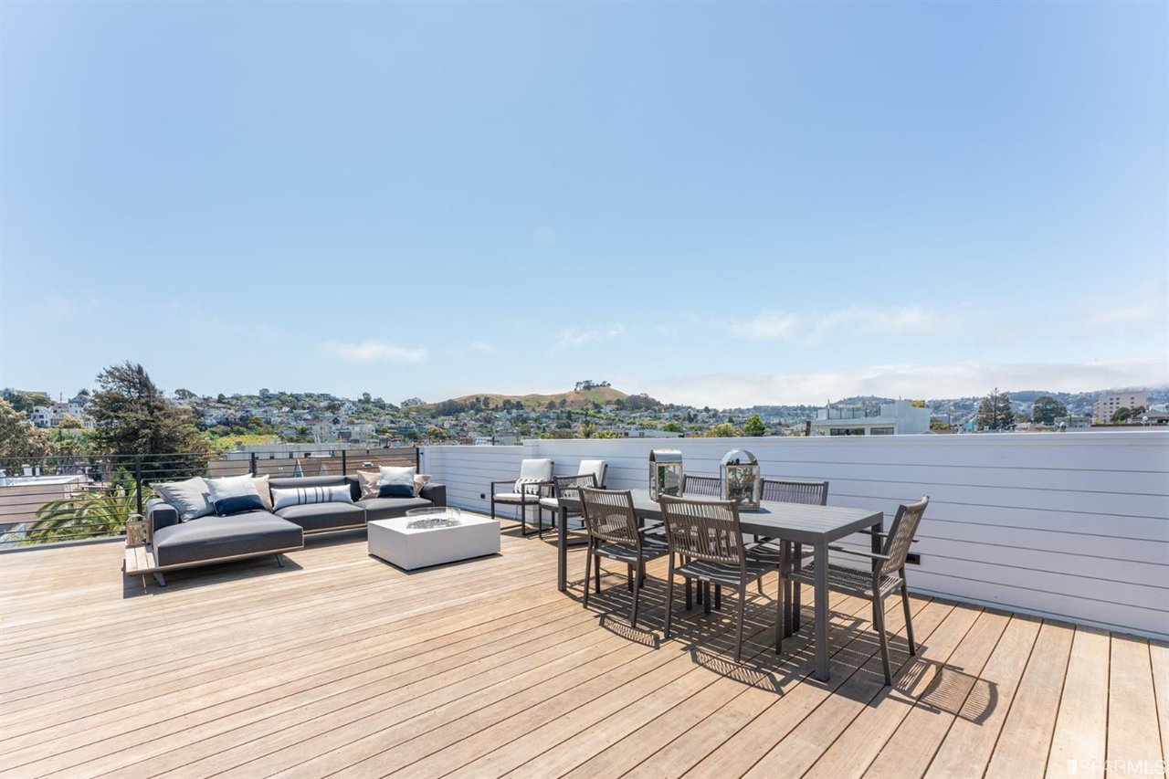 Rooftop deck with dining area, lounge seating, and bay views