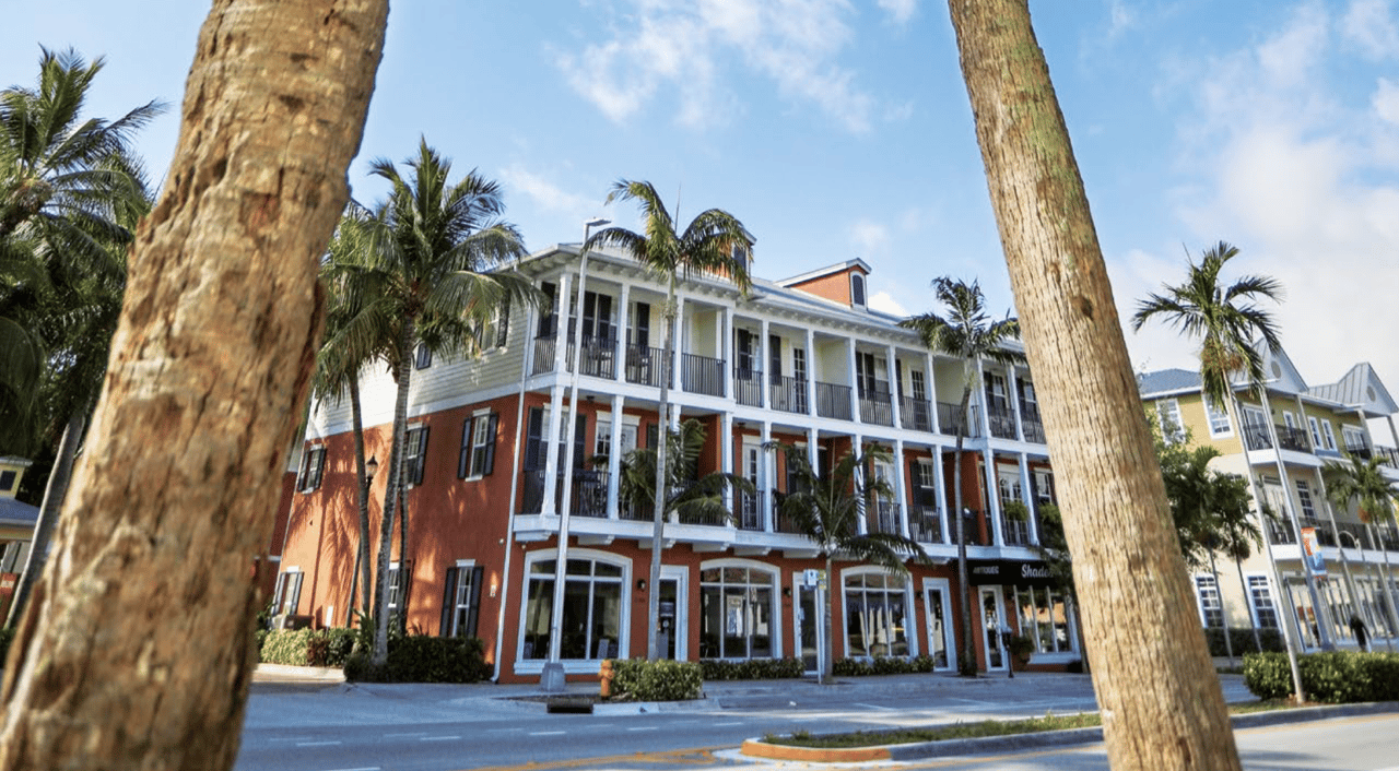 Colorful Mediterranean-style buildings with shops and palm trees along Wilton Drive in Wilton Manors, Florida.