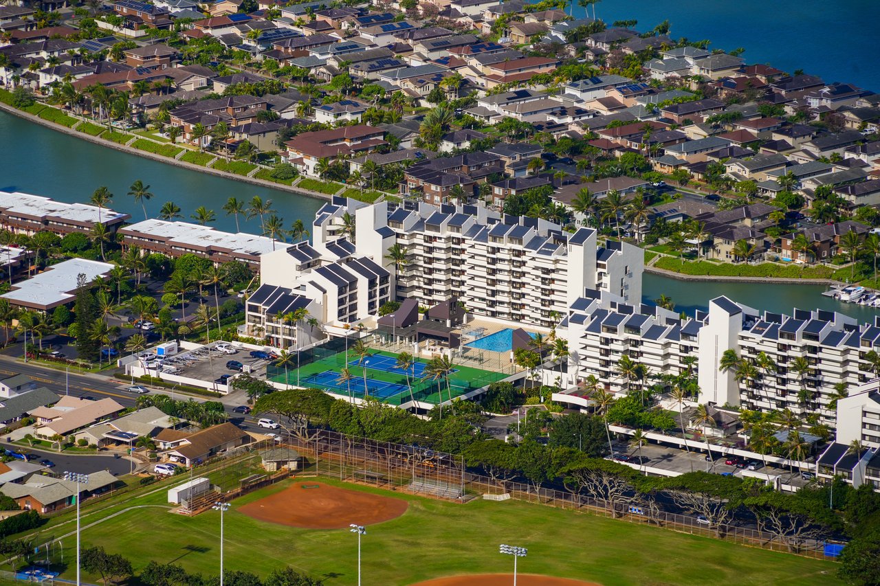 Admiralty Point condos beside a canal, with a pool, tennis courts, and nearby baseball fields.