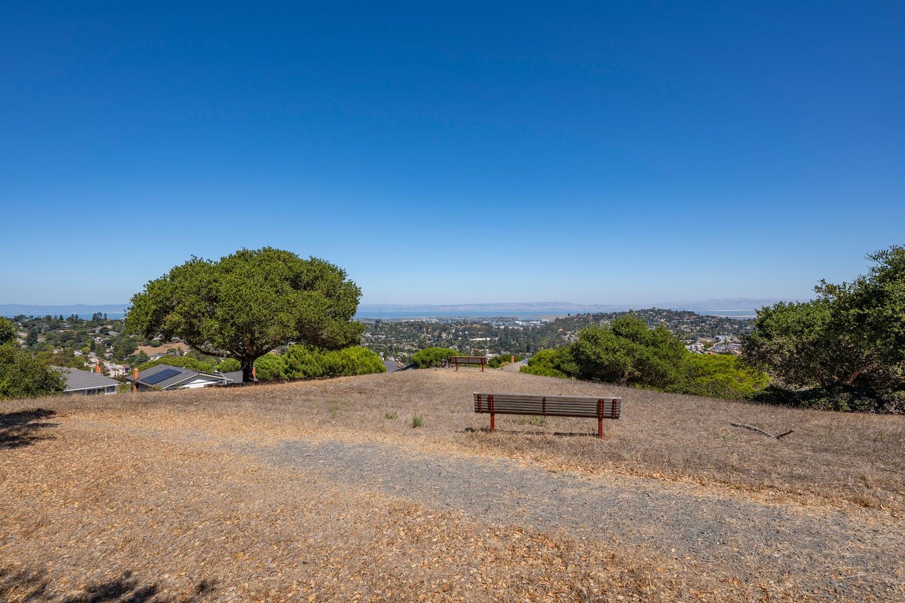 Park bench on a hilltop in Belmont, California, overlooking a sweeping vista of the San Francisco Bay Area on a clear day.