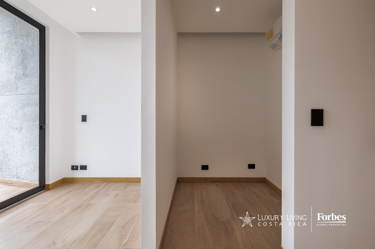 Empty modern interior with light wood floors, a large sliding glass door, and a deep recessed alcove.