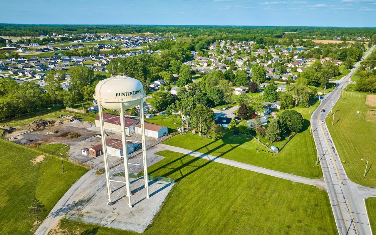 Aerial view of Huntertown, with its water tower in the foreground and neighborhoods stretching behind it.