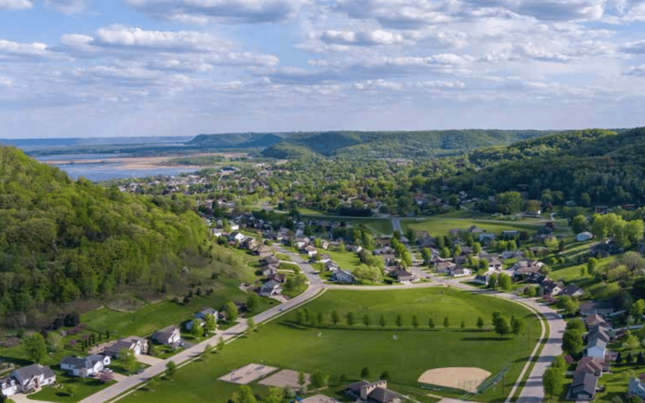 Aerial view of La Crescent, Minnesota, with the Mississippi River, rolling bluffs, and lush river valley landscape showcasing the area's natural beauty.