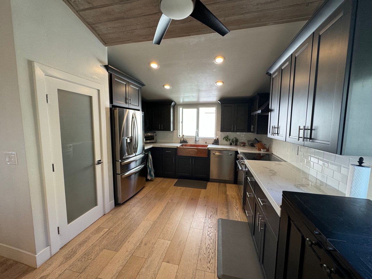 Spacious kitchen with dark cabinetry, stainless steel appliances, farmhouse sink, and quartz countertops at 533 S Sierra Ave, Solana Beach, CA 92075 oceanview rental.